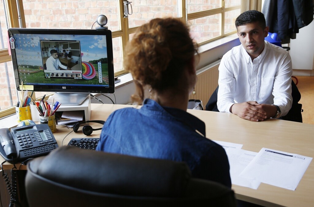 Unemployed Belgian Mohamed Sammar (R) answers questions during a simulated job interview, which is recorded to help him get feedback afterwards in Brussels July 2, 2013. Sammar, 27, has been looking for a job in the construction sector for 2 years. "Fit for a job" is the initiative of former Belgian boxing champion Bea Diallo, whose goal was to restore the confidence of unemployed people and help them find a job through their participation in sports. Picture taken July 2, 2013. REUTERS/Francois Lenoir (BELGIUM - Tags: SPORT BOXING SOCIETY BUSINESS EMPLOYMENT) - RTX11DQK