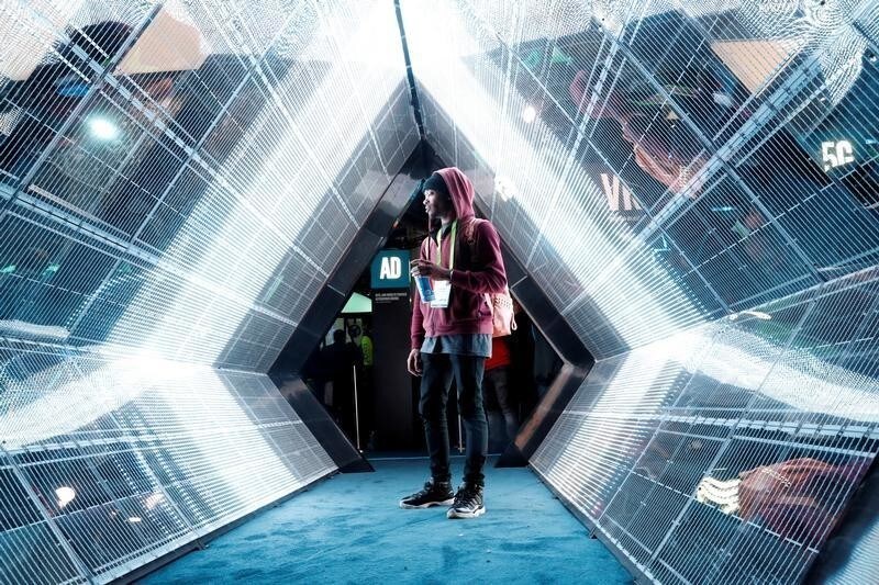 Jordan Jtakin walks though a 5G wireless broadband technology display in the Intel booth during the 2018 CES in Las Vegas, Nevada, U.S. January 9, 2018. REUTERS/Steve Marcus TPX IMAGES OF THE DAY - RC1CD0627130