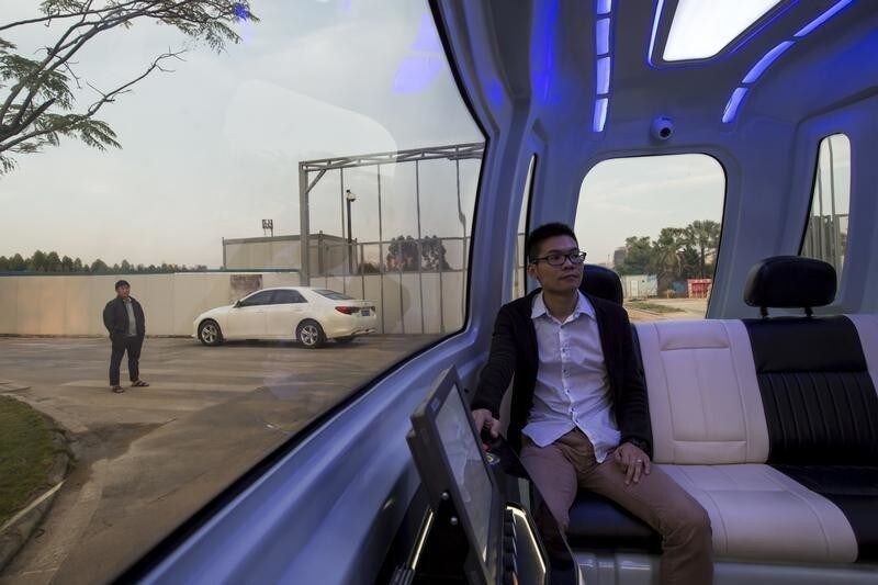 Zhang Jinming, who is in charge of the driverless car project, poses for a photo inside a driverless vehicle at Vanke's Building Research Centre in Dongguan, south China's Guangdong province, November 2, 2015. The country's largest property developer, China Vanke, is investing in its own robots to do certain jobs in the face of a labor shortage in the world's most populated country. This driverless car is among the robots that Vanke is aiming to bring in. Picture taken November 2, 2015. REUTERS/Tyrone Siu