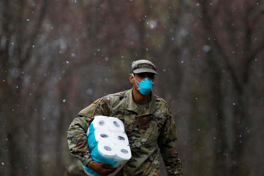 A member of Joint Task Force 2, composed of soldiers and airmen from the New York Army and Air National Guard, wears a face mask while carrying paper towels as he arrives to sanitize and disinfect the Young Israel of New Rochelle synagogue, as snow falls during the coronavirus disease (COVID-19) outbreak in New Rochelle, New York, U.S., March 23, 2020. REUTERS/Andrew Kelly - RC2RPF9XLLG9