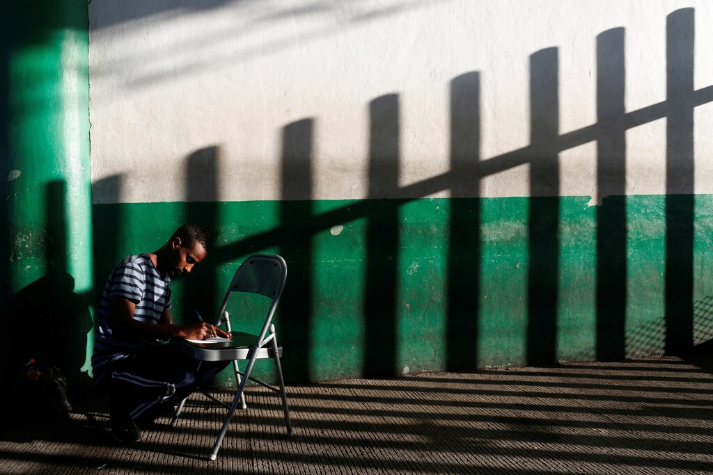 A Somali migrant fills a form outside the immigration office to cross Mexico and continue his journey to the U.S in Tapachula, Chiapas, Mexico November 16, 2016. REUTERS/Carlos Jasso TPX IMAGES OF THE DAY - S1BEUNGJXHAB