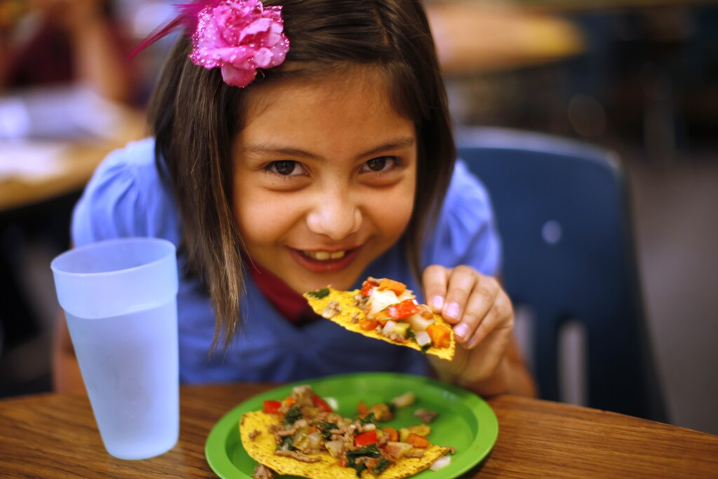 Ruby Mendoza, a student in the Munroe Elementary School gardening club, enjoys a meal she helped prepare by growing and chopping vegetables at the school in Denver, Colorado May 9, 2012.