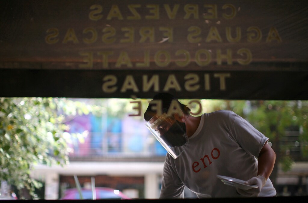 A waiter wearing a protective mask and face shield works at Eno restaurant during the start of the gradual reopening of commercial activities in Mexico City, Mexico, as the coronavirus disease (COVID-19) outbreak continues, July 2, 2020. REUTERS/Edgard Garrido - RC2ALH9F1P7N