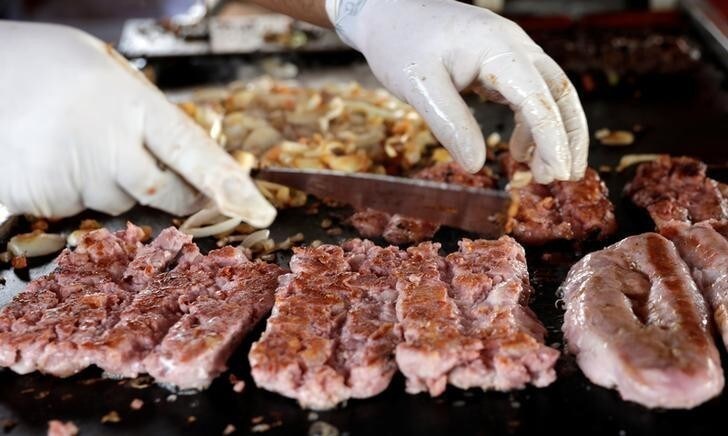 A worker prepares pork meat in a food truck in Sao Paulo, Brazil October 1, 2017. REUTERS/Paulo Whitaker