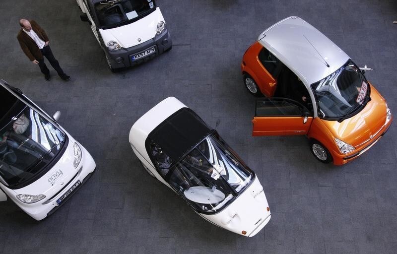 A man walks through a selection of electric and eco-friendly cars at the UK AWARE exhibition at Olympia in London April 18, 2009. Britain's Chancellor of the Exchequer, Alistair Darling is set to deliver the gloomiest budget in a generation on April 22, 2009, as government borrowing soars to a record high and the economy shrinks at its fastest pace since World War 2. . Photograph taken on April 18, 2009. REUTERS/Luke MacGregor (BRITAIN BUSINESS ENERGY ENVIRONMENT SOCIETY) - LM1E54M0NYE01