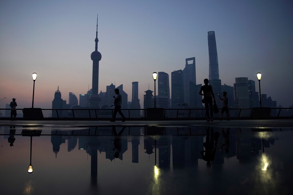 People walks on the bund in front of the financial district of Pudong in Shanghai, China July 27, 2017. REUTERS/Aly Song - RTX3D23V