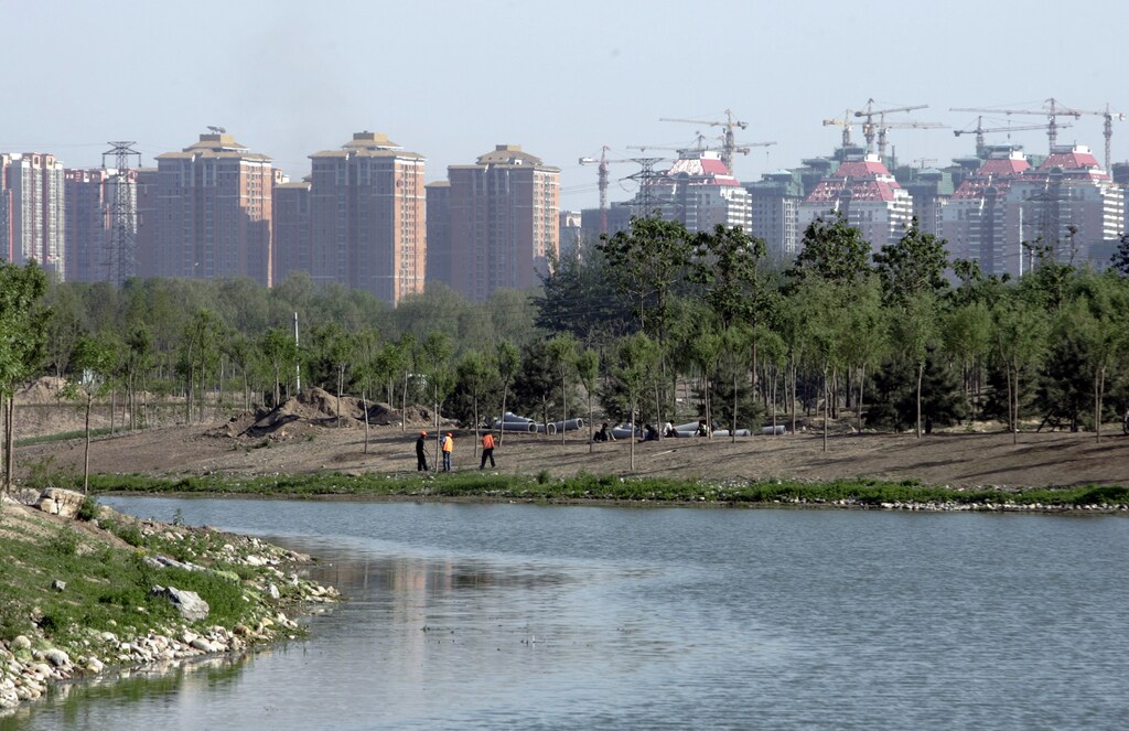 Workers plant trees near a river inside the Olympic Park, which is under construction, in Beijing May 9, 2007. REUTERS/Jason Lee (CHINA) - RTR1PHTQ