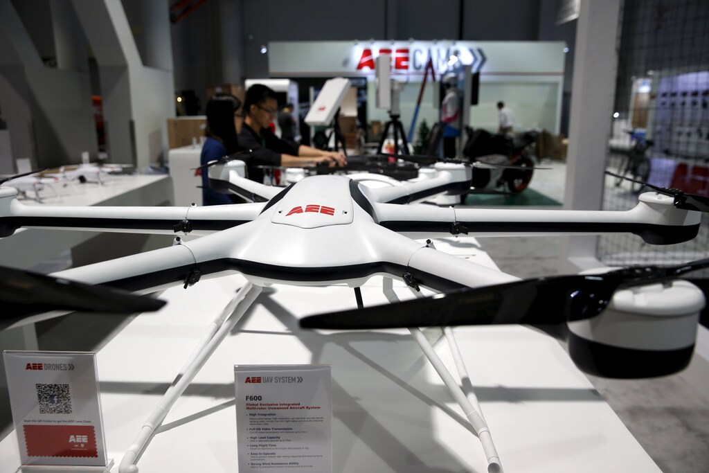 Workers set up a commercial drone display at the AEE Technology booth in the Las Vegas Convention Center during set-up for the 2016 CES trade show in Las Vegas, Nevada, January 5, 2016.