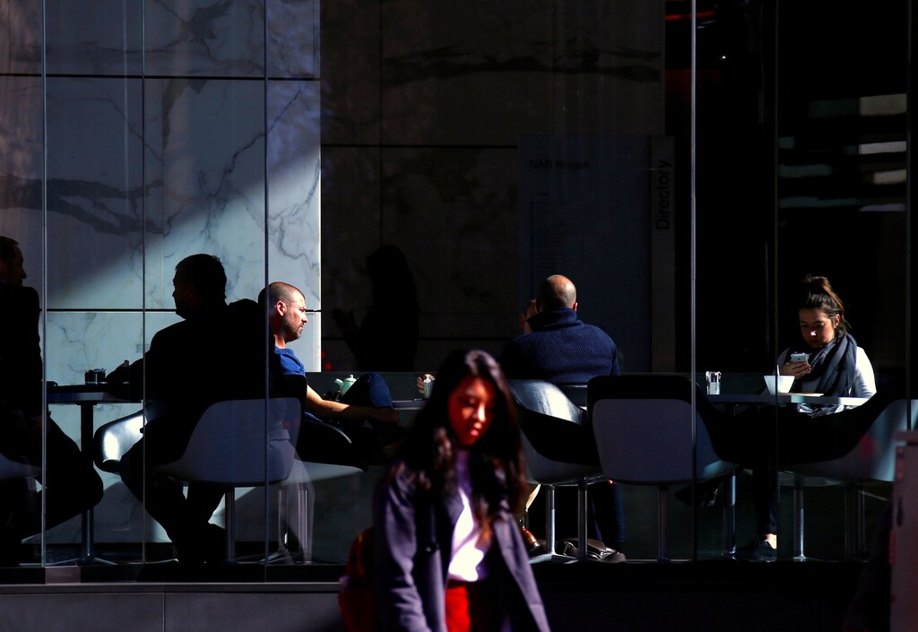 A woman uses her phone as she sits with other customers at a cafe in central Sydney, Australia, July 7, 2017. REUTERS/David Gray - RTX3AETL