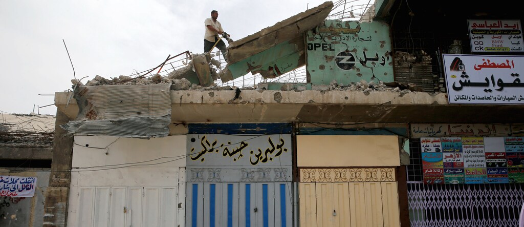 A worker removes rubble during the rebuilding of a building destroyed during fighting between Iraqi forces and Islamic state fighters, eastern Mosul, Iraq, April 21, 2017. Picture taken April 21, 2017. REUTERS/ Muhammad Hamed