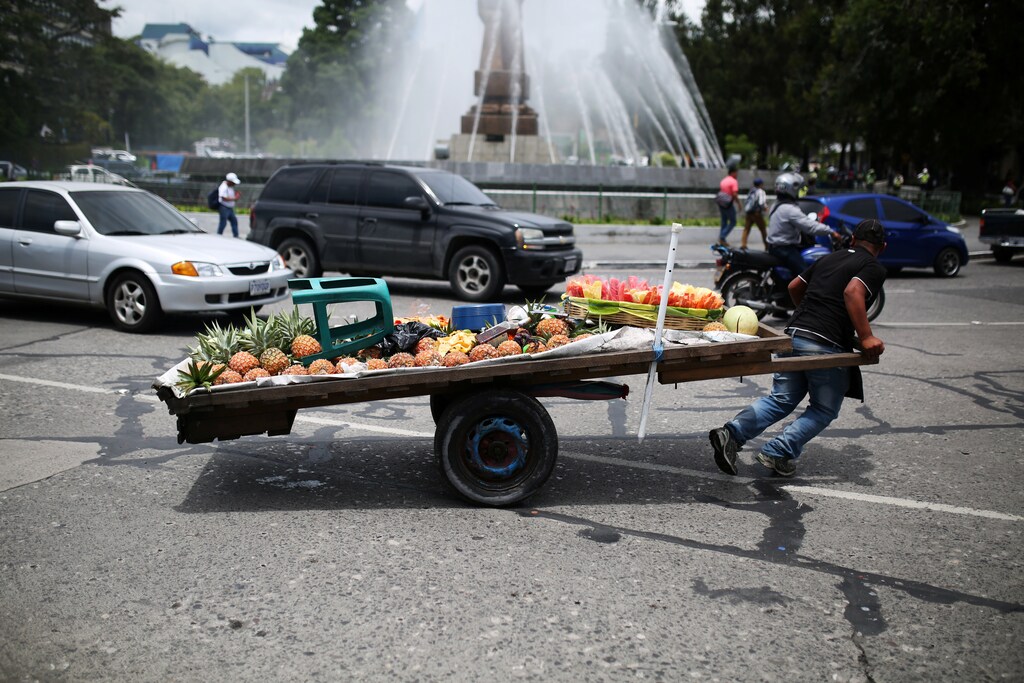 A fruit seller pulls his cart in Guatemala City, Guatemala.