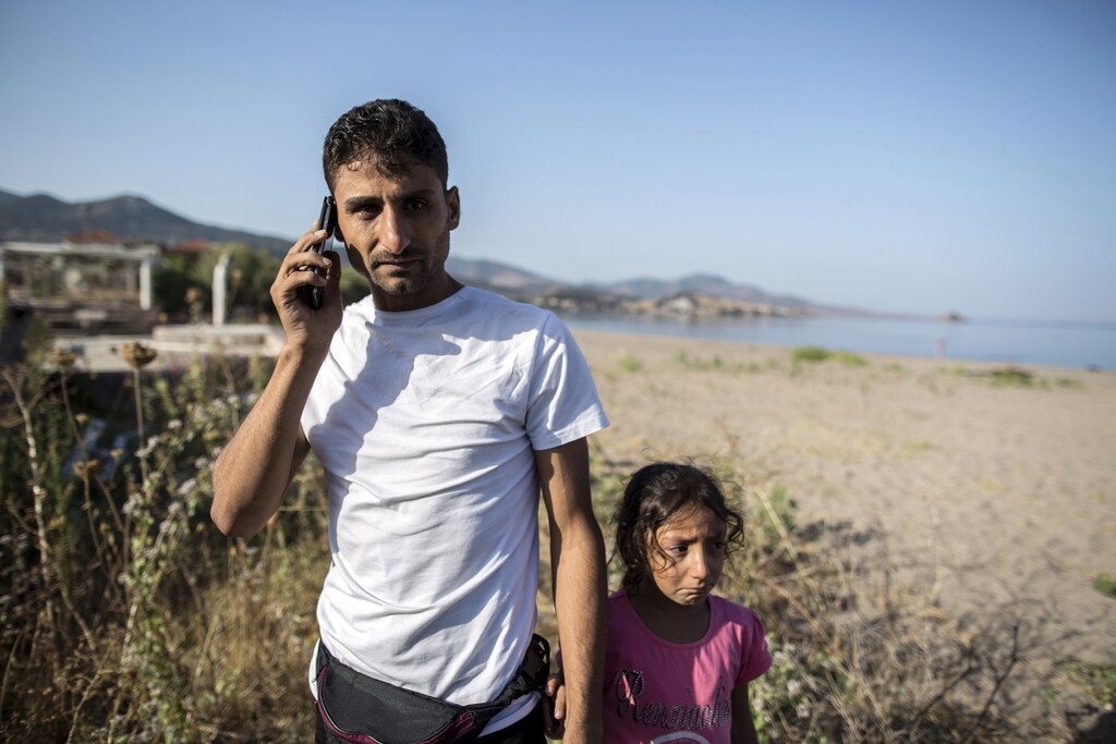 Ihab, a 30-year-old Syrian migrant from Deir Al Zour, reacts as he talks on the phone with his mother, who has been a refugee in Germany for two months, at the beach after arriving on the Greek island of Lesbos September 11, 2015. The crossing from Turkey and the eventual trip to Athens is only the beginning for Ihab and other families. Ahead lies a trek north through Greece, up via Macedonia and Serbia to Hungary and on to Austria, Germany and more industrialised countries. Picture taken September 11, 2015. REUTERS/Zohra Bensemra - RTS1518