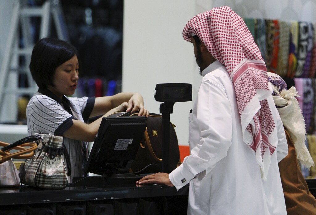 A saleswoman attends to a customer at the cash counter inside a shop at Dragon Mart in Dubai, March 2, 2011. Built in the shape of a dragon, the 1.2 km long and 150,000 sqm large mall is a trading centre with almost 3,950 shops selling mainly Chinese products ranging from office appliances to garments and daily products. Picture taken March 2, 2011. REUTERS/Jumana El Heloueh (UNITED ARAB EMIRATES - Tags: BUSINESS) - GM1E73318X601