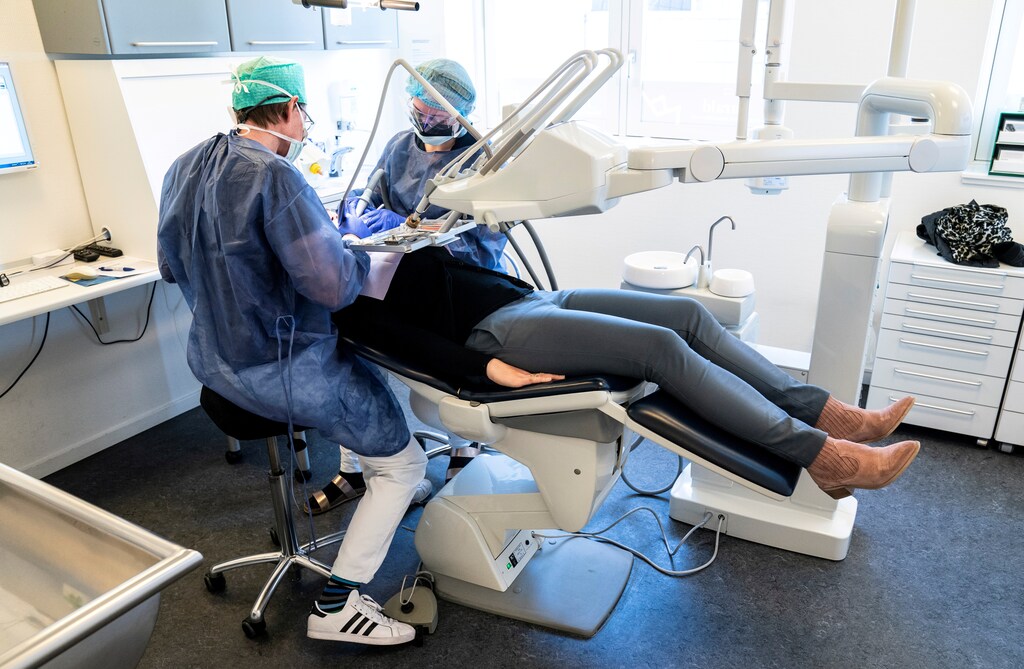 Dentist Torben Schoenwaldt and clinical assistant student Rebecka Erichsen work in reopened Harald Dentists Soenderaaparken, as the country loosens the restrictions amid the spread of the coronavirus disease (COVID-19), in Vejle, Denmark April 20, 2020. Ritzau Scanpix/Claus Fisker via REUTERS ATTENTION EDITORS - THIS IMAGE WAS PROVIDED BY A THIRD PARTY. DENMARK OUT. NO COMMERCIAL OR EDITORIAL SALES IN DENMARK. - RC288G9UD5EE