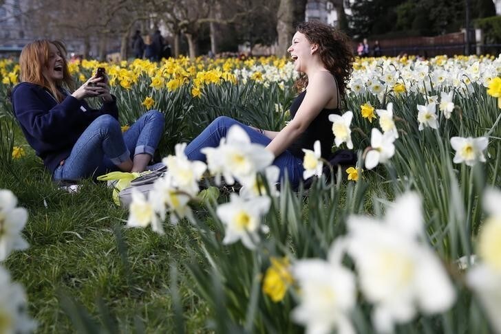 Women laugh amid the daffodils in Green Park in central London March 15, 2014. REUTERS/Olivia Harris (BRITAIN - Tags: CITYSCAPE ENVIRONMENT)