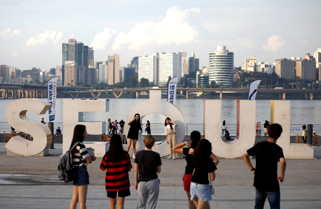 Tourists pose for photographs at the Han river park in Seoul, South Korea, August 1, 2017. REUTERS/Kim Hong-Ji - RC1170B590D0