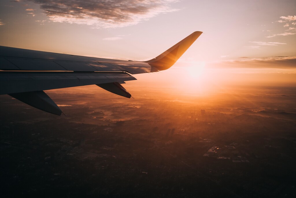 Plane wing in the sky over a sunset.