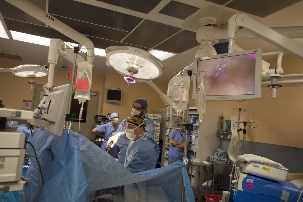 Surgeons Lloyd Ratner (R) and Karim Zalazun (L) harvest a donor kidney for patient Andrew Abernathy, who participated in a five-way organ transplant swap, in New York, August 1, 2012. Abernathy's partner David Ferguson donated a kidney for transplant to a stranger while at the same time someone else donated a kidney to Abernathy as part of chain of kidney donations that allowed five people to receive a transplanted kidney over a two day period. The health dangers for kidney donors is believed to be low. The risk of death from the surgery is 1 in 1,700, according to the National Kidney Foundation, and life expectancy is said to be unchanged with one kidney. Picture taken August 1, 2012. To match story USA-KIDNEY/SWAP REUTERS/Keith Bedford (UNITED STATES - Tags: HEALTH SOCIETY) - GM2E884068Y01