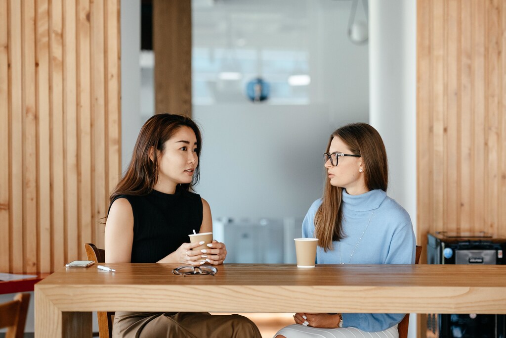 Two women having a coffee in an office.