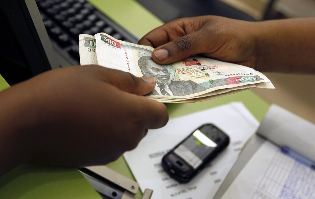 A customer conducts a mobile money transfer, known as M-Pesa, inside the Safaricom mobile phone care centre in the central business district of Kenya's capital Nairobi July 15, 2013. To match Insight AFRICA-MOBILEMONEY/ Picture taken July 15, 2013. REUTERS/Thomas Mukoya (KENYA - Tags: BUSINESS TELECOMS) - GM1EA7U1QS601
