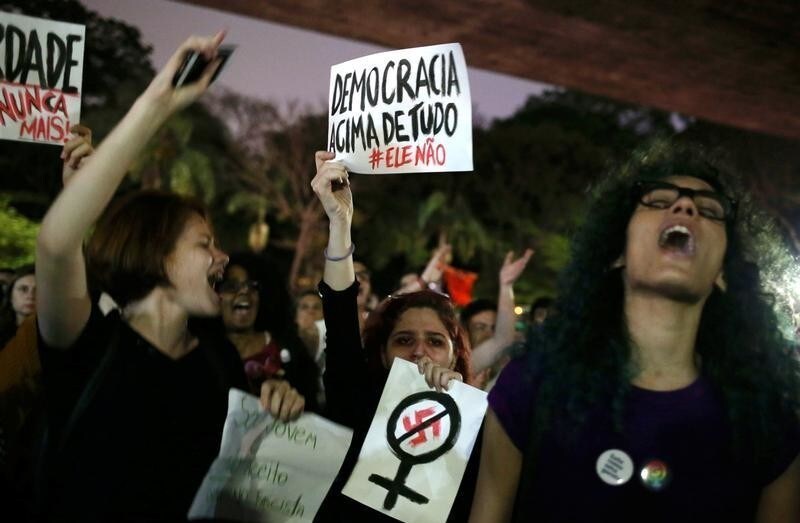 Demonstrators shout slogans against Jair Bolsonaro, far-right lawmaker and presidential candidate of the Social Liberal Party (PSL), during a protest called "dictatorship never again" in Sao Paulo, Brazil October 10, 2018. The poster (topC) reads: "Democracy above all else." REUTERS/Amanda Perobelli - RC14C5056CB0