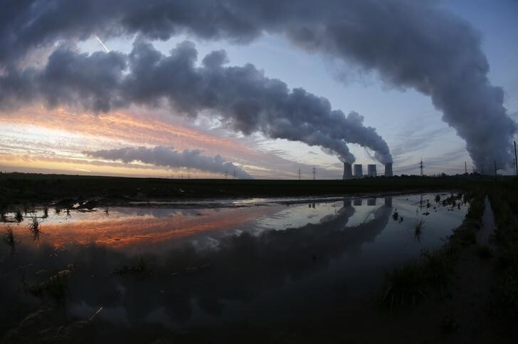 The coal power plant of German utility RWE Power is reflected in a puddle near the western town of Neurath November 14, 2013. RWE said it would cut more jobs and trim capital spending as it joined peers in warning of a deep crisis in Europe's energy industry that would keep a lid on growth in the foreseeable future. REUTERS/Ina Fassbender (GERMANY - Tags: BUSINESS ENERGY EMPLOYMENT TPX IMAGES OF THE DAY)