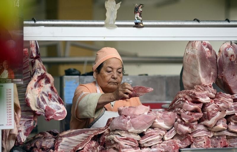A vendor arranges pieces of meat at her stall at the Central market in Quito August 26, 2014. It costs about $7 for a kilogram of meat. Ecuador began using U.S. dollars as legal tender since 2000. REUTERS/Guillermo Granja (ECUADOR - Tags: FOOD BUSINESS) - GM1EA8R0YQ301