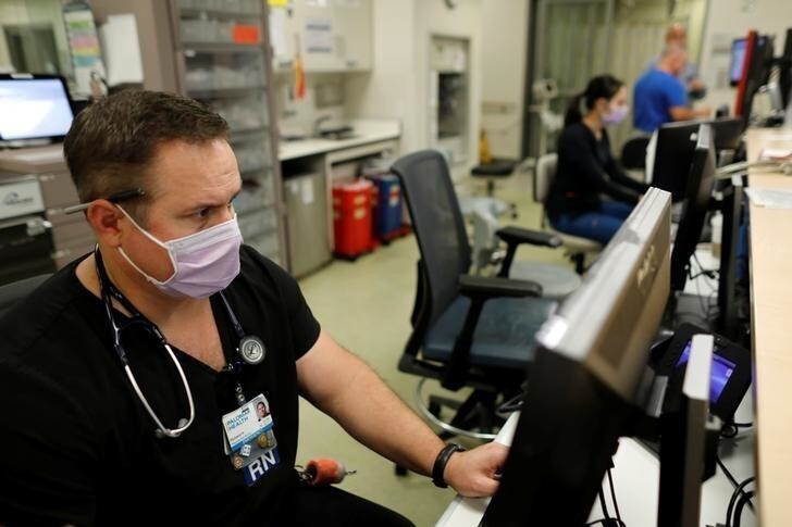 Emergency room nurse Richard Horner wears a mask as he deals with flu patients at Palomar Medical Center in Escondido, California, U.S., January 18, 2018. REUTERS/Mike Blake