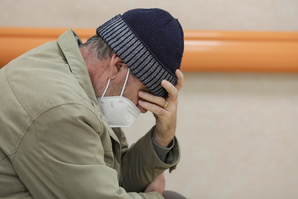 A coronavirus disease (COVID-19) patient wearing a PPE mask sits in the emergency unit hallway of the National Institute for Infectious Diseases "Matei Bals" in Bucharest, Romania, October 11, 2021. Inquam Photos/Octav Ganea via REUTERS ATTENTION EDITORS - THIS IMAGE WAS PROVIDED BY A THIRD PARTY. ROMANIA OUT. NO COMMERCIAL OR EDITORIAL SALES IN ROMANIA - RC2I7Q9ED4A9