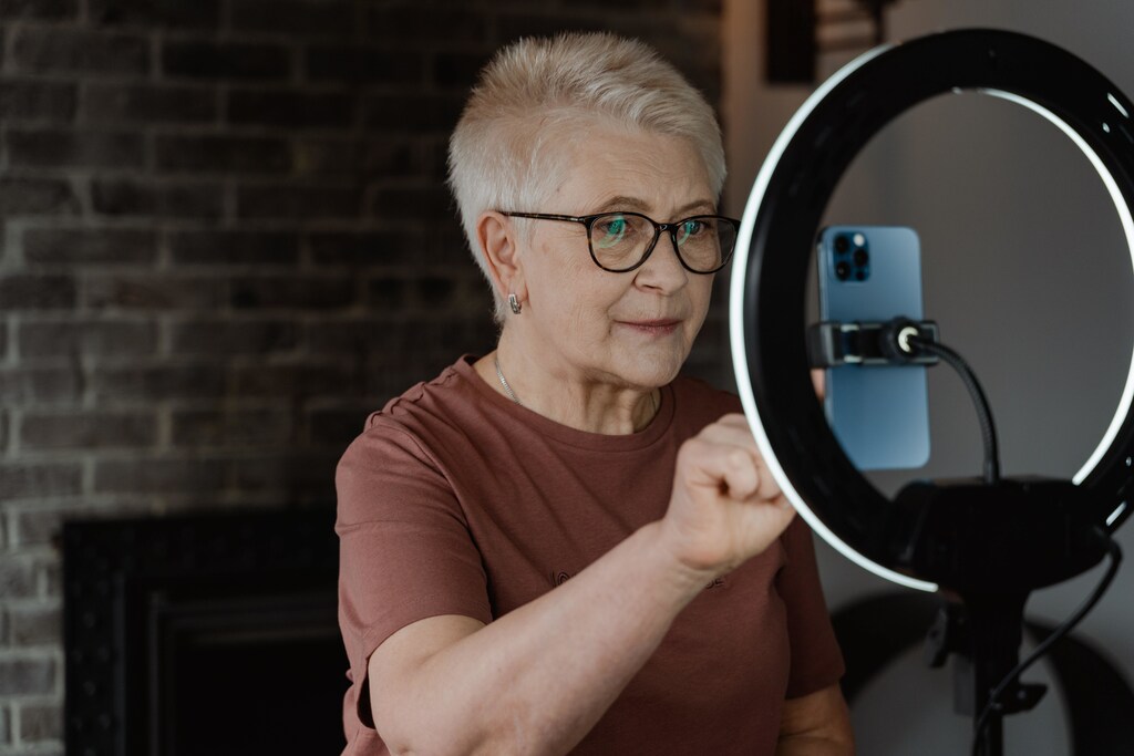 Healthy ageing – older woman using phone with ring light.