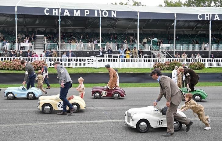 Parents assist whilst children prepare to compete in a pedal car race as motoring enthusiasts attend the Goodwood Revival, a three day classic car racing festival celebrating the mid-twentieth century heyday of the sport, at Goodwood in southern Britain, September 9, 2018. REUTERS/Toby Melville