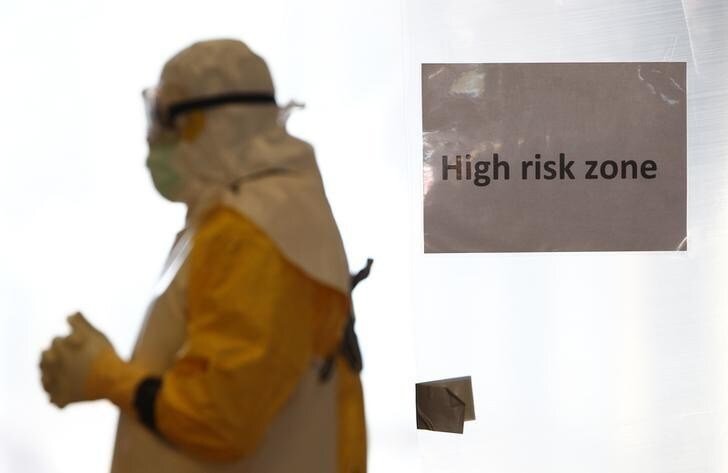 A volunteer wearing a protective suit walks in a 'high risk' zone during an Ebola training session held by Germany's Red Cross in Wuerzburg October 21, 2014. The German Red Cross is training volunteer doctors, nurses and engineers to fight Ebola in western Africa. REUTERS/Michaela Rehle (GERMANY - Tags: HEALTH POLITICS TPX IMAGES OF THE DAY)