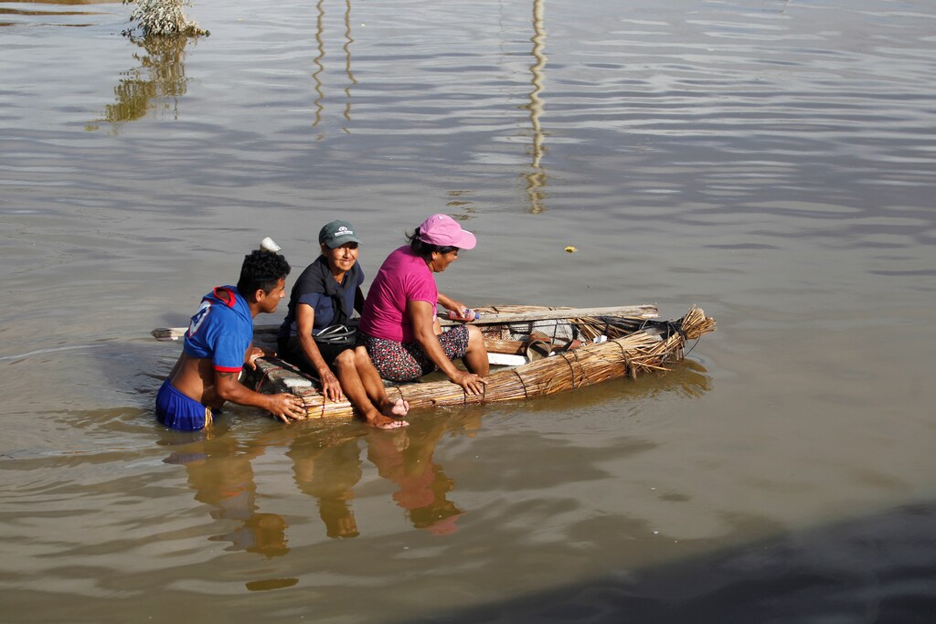 Residents use a raft to cross a flooded street, after rivers breached their banks due to torrential rains, causing flooding and widespread destruction in Huarmey, Ancash, Peru, March 21, 2017. REUTERS/Guadalupe Pardo - RTX322MF