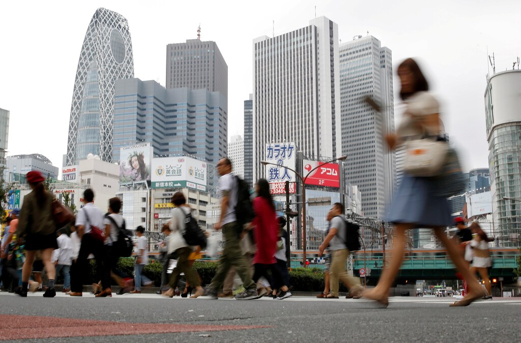 People cross a street in front of high-rise buildings in the Shinjuku district in Tokyo, Japan, September 29, 2016. REUTERS/Toru Hanai/File Photo - RTX2P2WY
