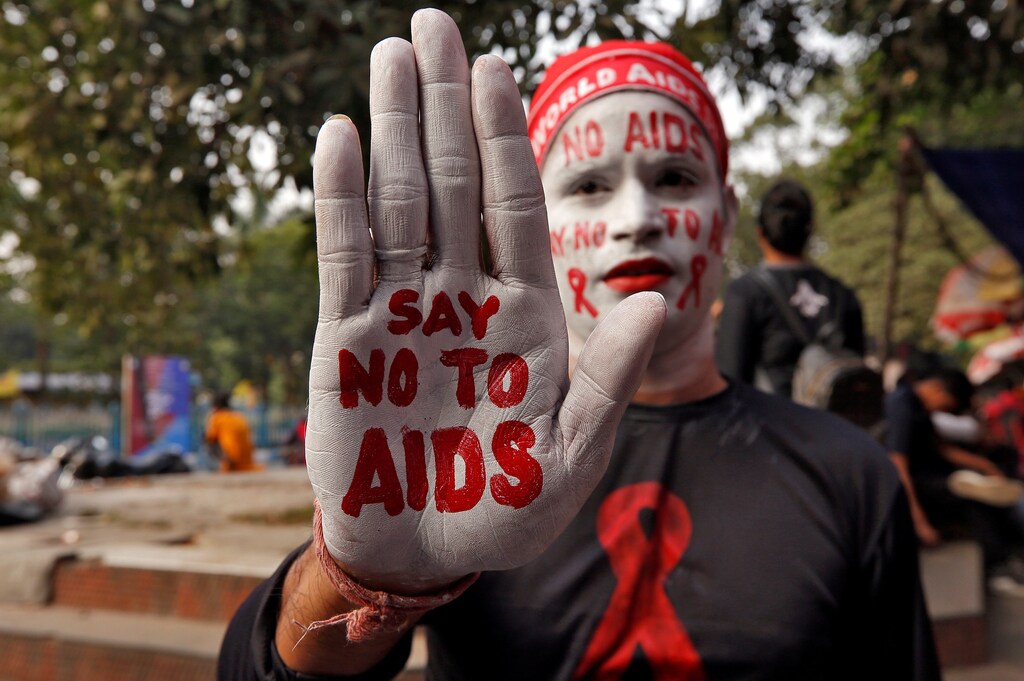 A man poses as he displays his hand and face painted with messages during an HIV/AIDS awareness campaign on the eve of World AIDS Day in Kolkata, India, November 30, 2018. REUTERS/Rupak De Chowdhuri - RC127FB93D70