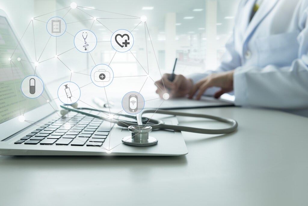 Doctor using a laptop computer contact with patient: Scalable digital solutions and AI in healthcare can't be done in isolation