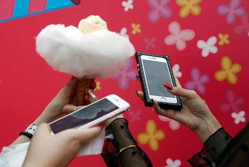 Instagramer SHIHO and her friend look at their mobile after taking photos of Anywhere Door's 'Cotton Candy Ice' during the Photogenic Sweets Festa at a shopping mall in Tokyo, Japan, September 15, 2017.