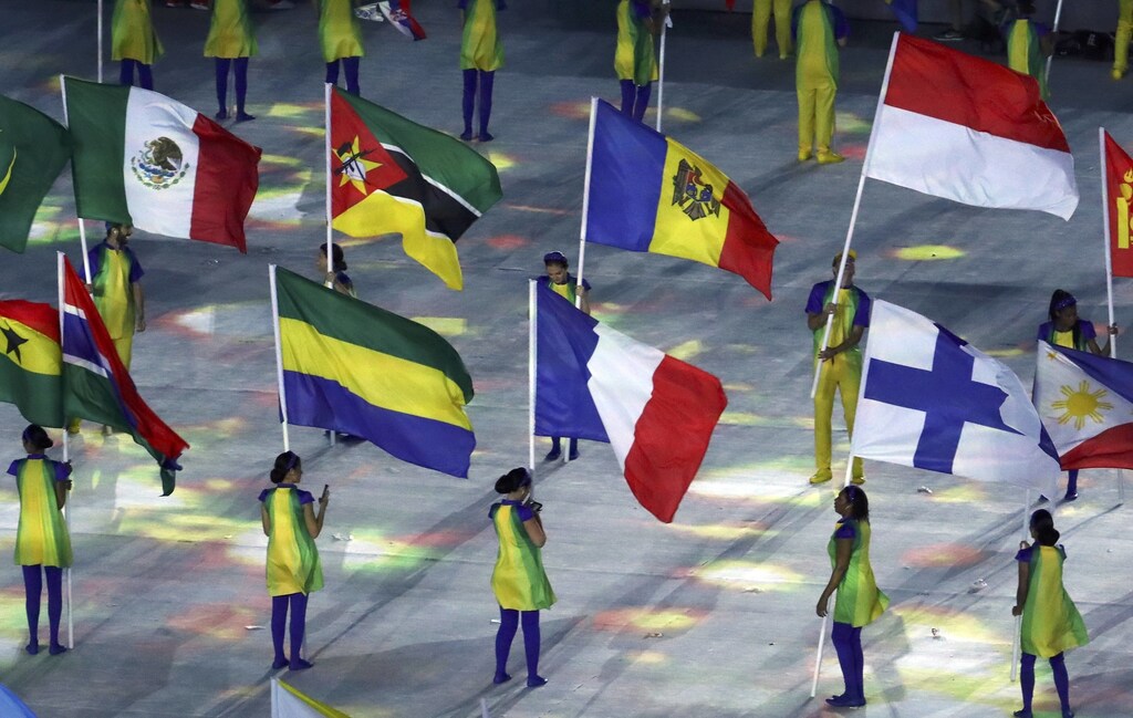 2016 Rio Olympics - Closing Ceremony - Maracana - Rio de Janeiro, Brazil - 21/08/2016. Volunteers hold flags of different countries, including France and Mexico. REUTERS/Yves Herman FOR EDITORIAL USE ONLY. NOT FOR SALE FOR MARKETING OR ADVERTISING CAMPAIGNS. - RTX2MGHB