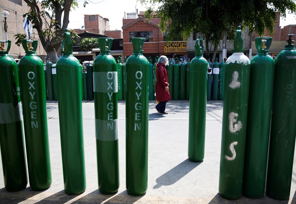 A woman walks among empty oxygen waiting tanks to be recharged at a private supplier during the outbreak of the coronavirus disease (COVID-19), in Lima, Peru January 27, 2021. REUTERS/Sebastian Castaneda - RC2QGL9QJU3P
