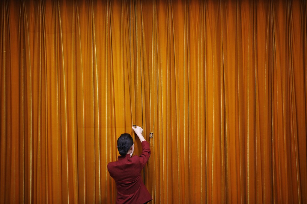 An attendant puts clamps on a curtain inside the Great Hall of the People during the closing ceremony of the Chinese People's Political Consultative Conference (CPPCC) in Beijing, March 12, 2014. REUTERS/Kim Kyung-Hoon (CHINA - Tags: POLITICS TPX IMAGES OF THE DAY) - GM1EA3C0Q4G02