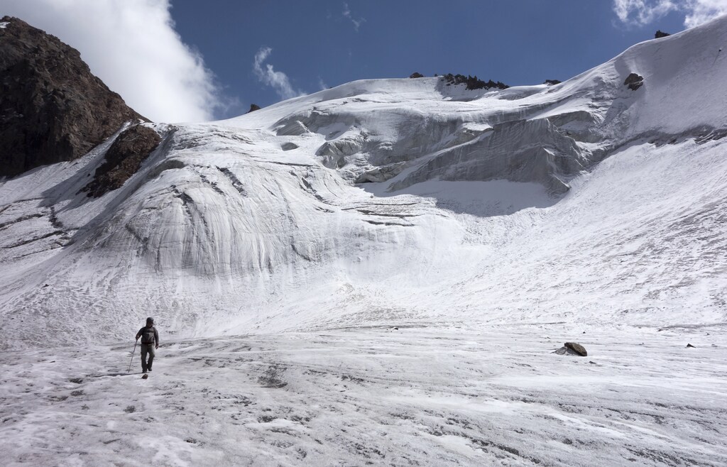 A tourist walks across the Manshuk Mametova glacier, about 3,550 metres (11,647 feet) above sea level, in the mountains of Tien Shan outside Almaty September 6, 2014. REUTERS/Shamil Zhumatov (KAZAKHSTAN - Tags: SOCIETY TRAVEL ENVIRONMENT TPX IMAGES OF THE DAY) - GM1EA961LWP01