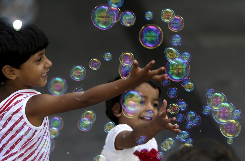 Migrant children play with bubbles at Keleti railway station in Budapest, Hungary, September 6, 2015.