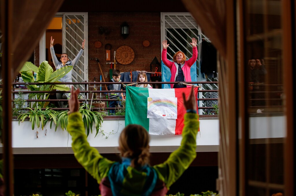 Personal trainer Antonietta Orsini carries out an exercise class for her neighbours from her balcony while Italians cannot leave their homes due to the coronavirus disease (COVID-19) outbreak, in Rome, Italy, March 18, 2020. Picture taken March 18, 2020 REUTERS/Remo Casilli TPX IMAGES OF THE DAY - RC2WMF9RAEOP