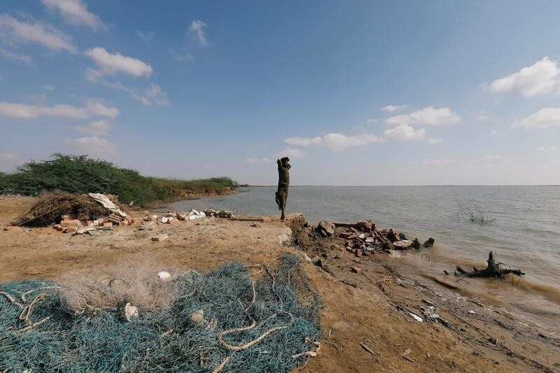 A boy stands at the area of a former village, lost due to seawater intrusion, in Kharo Chan, Pakistan November 12, 2018. REUTERS/Akhtar Soomro - RC1987BF4DE0