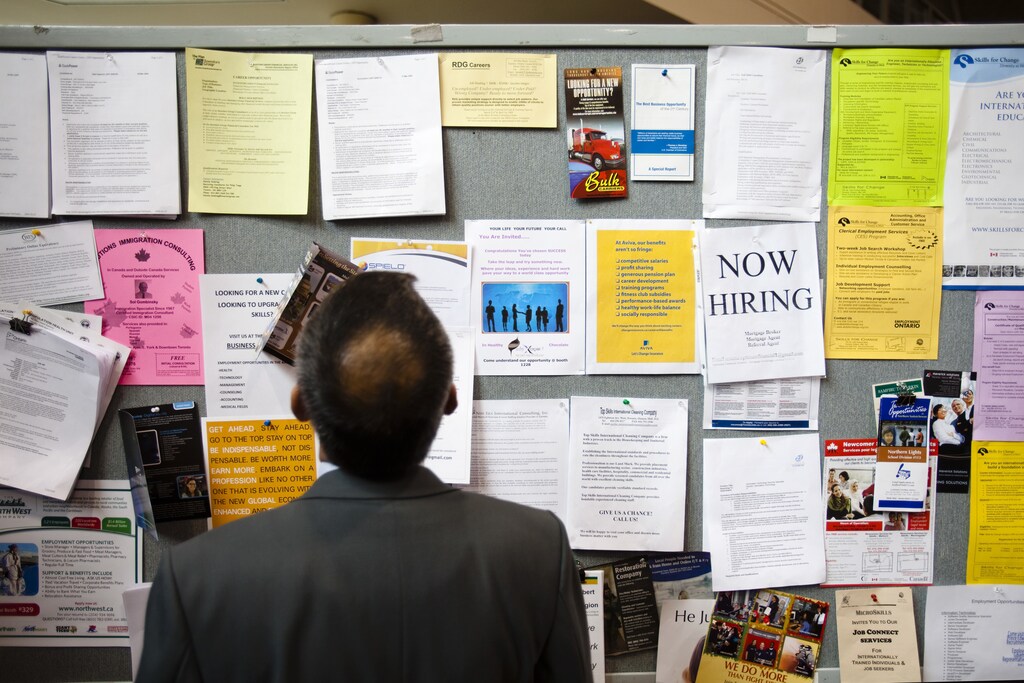 A man looks at a job board at a job fair in Toronto, April 1, 2009. REUTERS/Mark Blinch (CANADA BUSINESS) - GM1E5420DT701