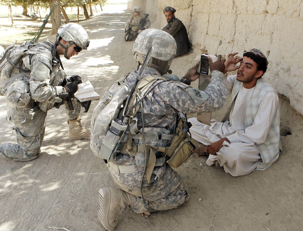 U.S. soldiers from 3rd Platoon, Bravo Company, 1-22 Infantry Battalion collect biometric data from two villagers during a patrol in Shingkay village in Kandahar province in southern Afghanistan October 4, 2010. REUTERS/Erik de Castro (AFGHANISTAN - Tags: MILITARY CONFLICT) - GM1E6A503B601