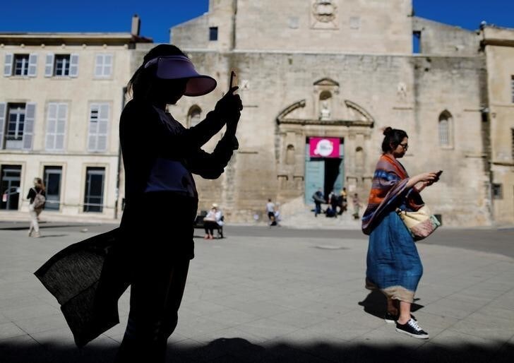 People use their mobile phones in downtown Arles, France July 3, 2017. REUTERS/Tony Gentile