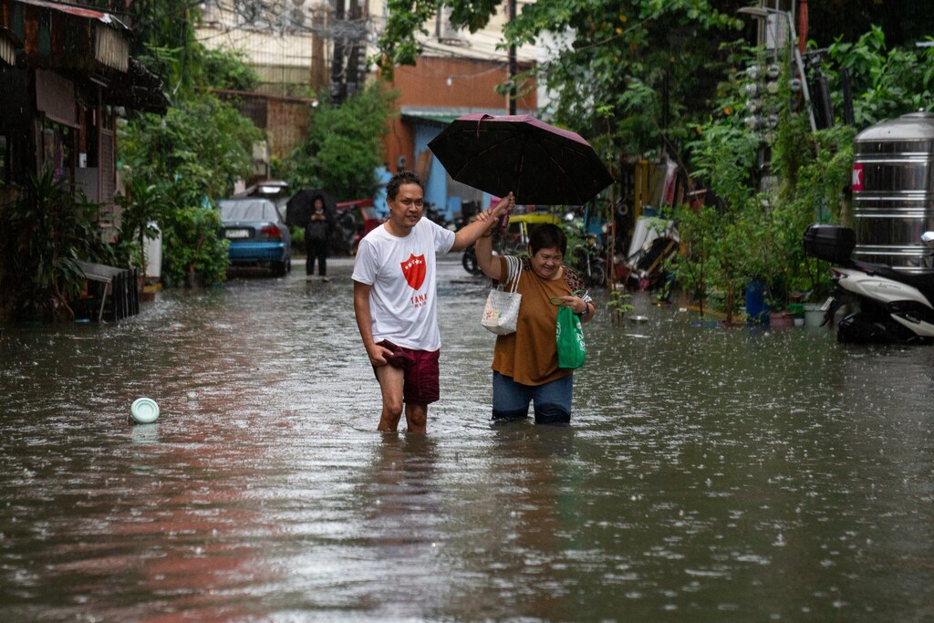 People wade through a flooded street amid heavy rains brought by Typhoon Gaemi, in Manila, Philippines, July 24, 2024. Climate change is expected to take a huge toll on global health.