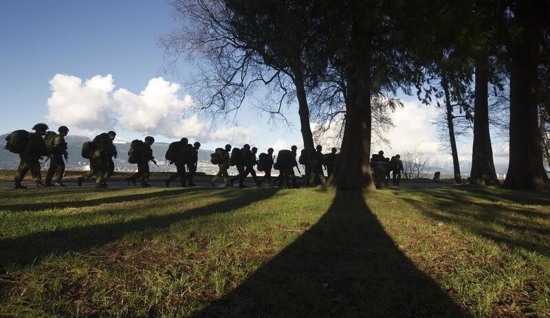 Canadian soldiers march with full packs along Kitsilano Beach in Vancouver, British Columbia January 10, 2013. The soldiers marched up and down the beach several times while training a forced march. REUTERS/Andy Clark (CANADA - Tags: SOCIETY MILITARY) - GM1E91B0LHF01
