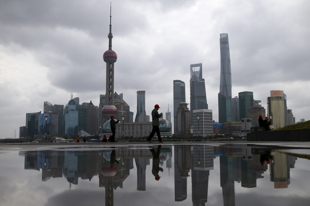 People walk on the bund in front of the financial district of Pudong in Shanghai, China March 9, 2016. REUTERS/Aly Song - GF10000338954